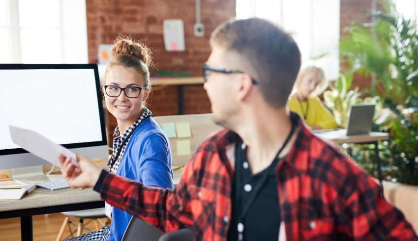 Two people in an office talking to each other.