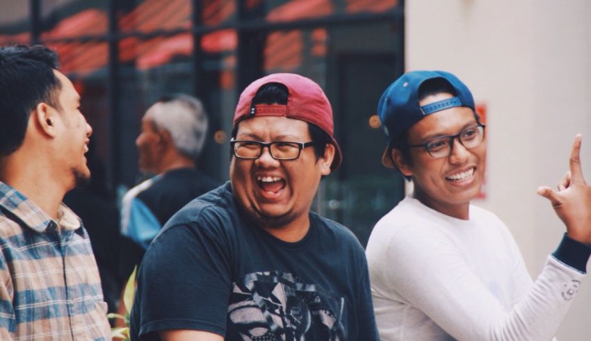 A group of men are laughing while standing next to each other.