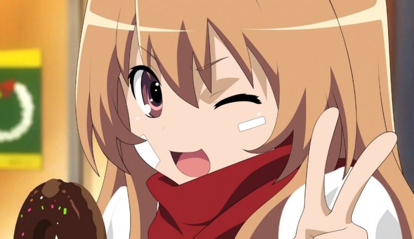 A girl with long blonde hair is holding a donut and making a peace sign.