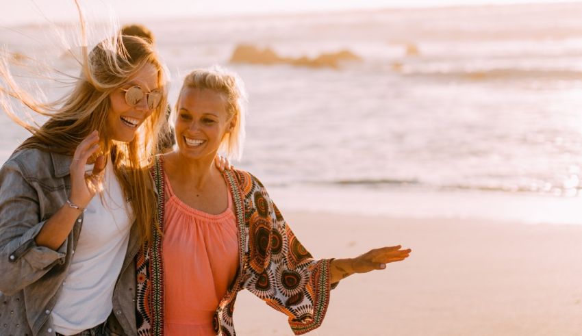 Two women laughing on the beach.