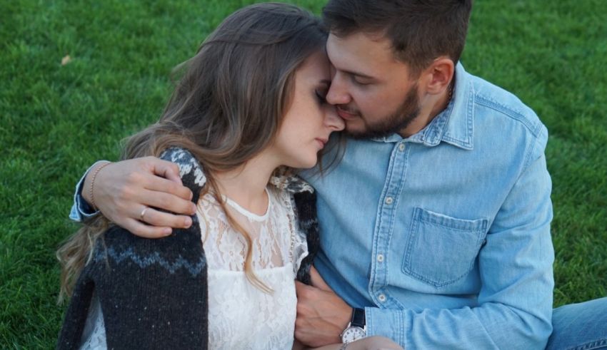 A man and woman hugging in the grass.