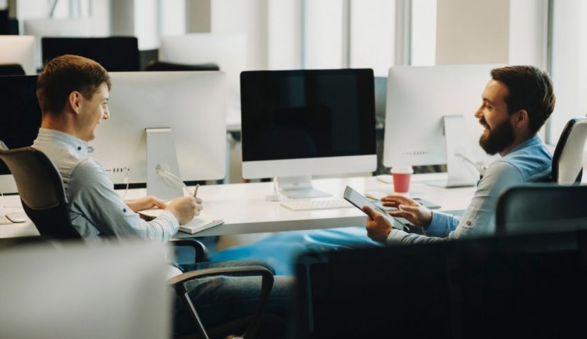 Two men sitting at desks in an office.