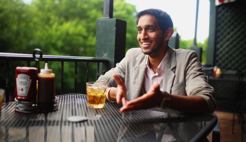 A man sitting at a table with a drink.
