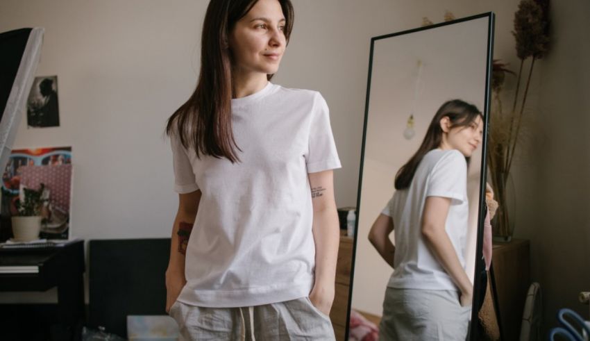 A woman in a white t - shirt standing in front of a mirror.