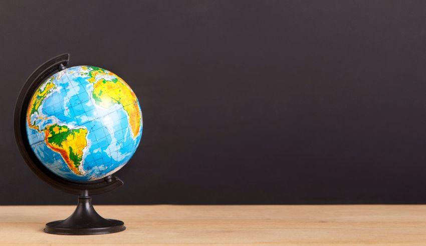 A globe on a wooden table with a black background.