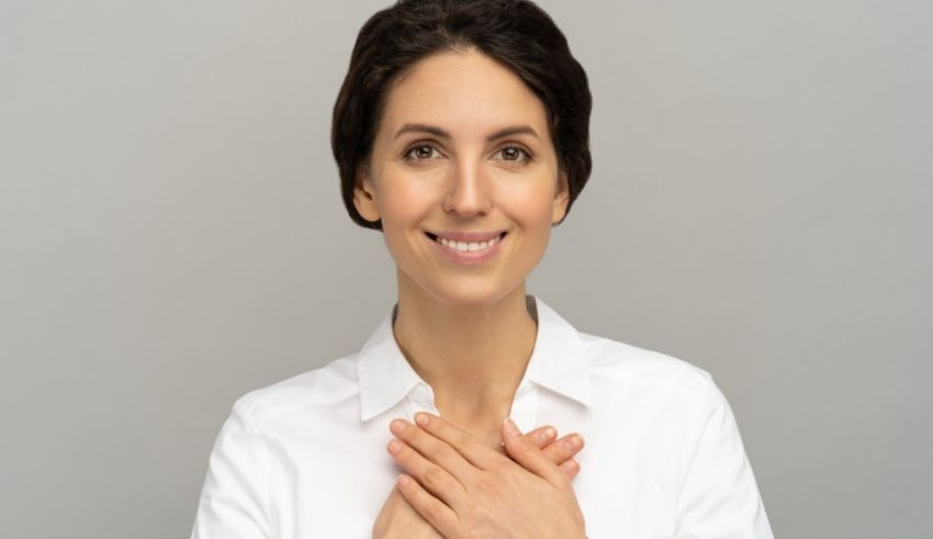 A woman with her hands clasped in front of her face.