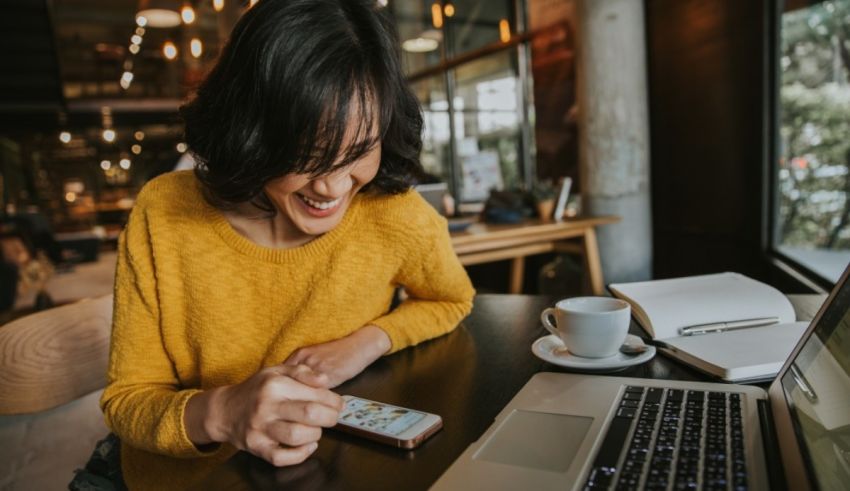 A woman sitting at a table with a laptop and a cup of coffee.