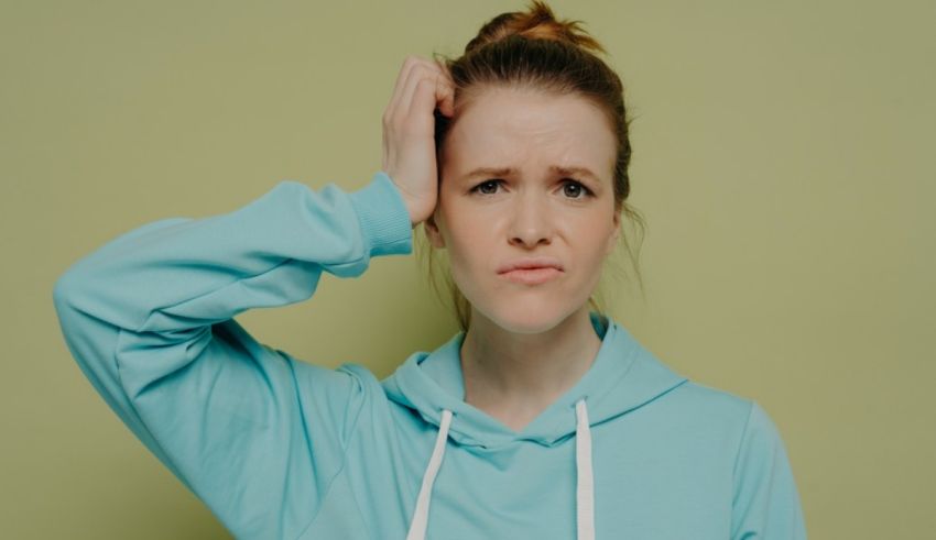 A young woman with her hands on her head.