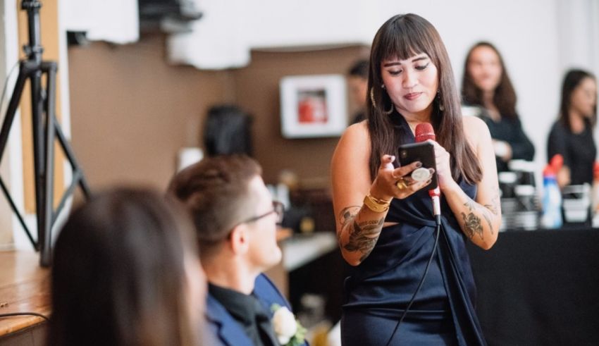 A woman is speaking into a microphone at a wedding.