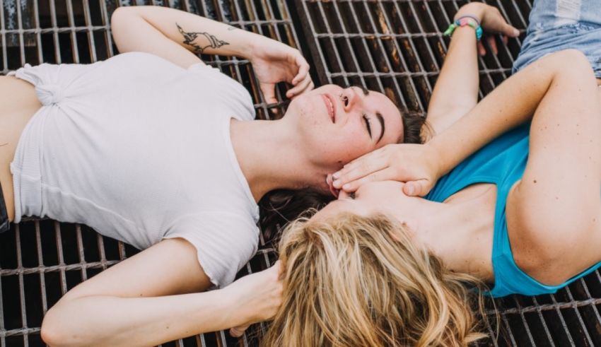 Two young women laying on a grate.