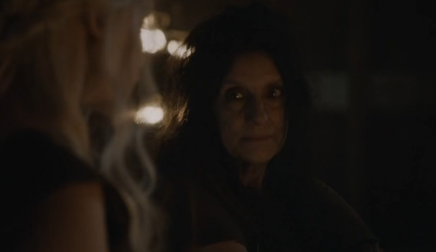 Two women in a dark room looking at each other.