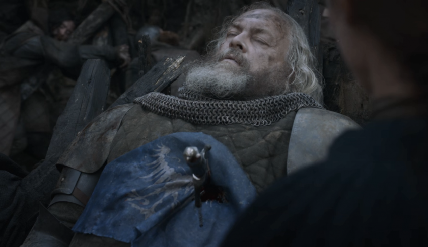 A man with a beard is laying down in a group of people.