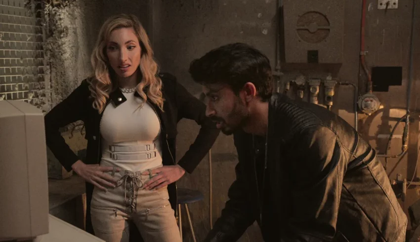 A man and woman standing next to a computer.