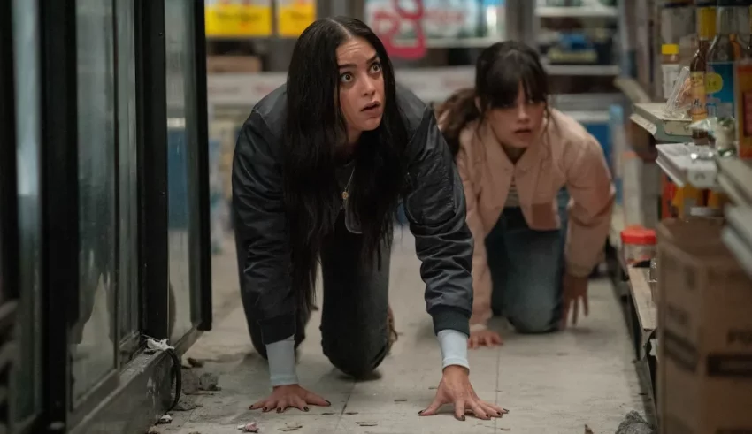 Two women crawling on the floor of a grocery store.